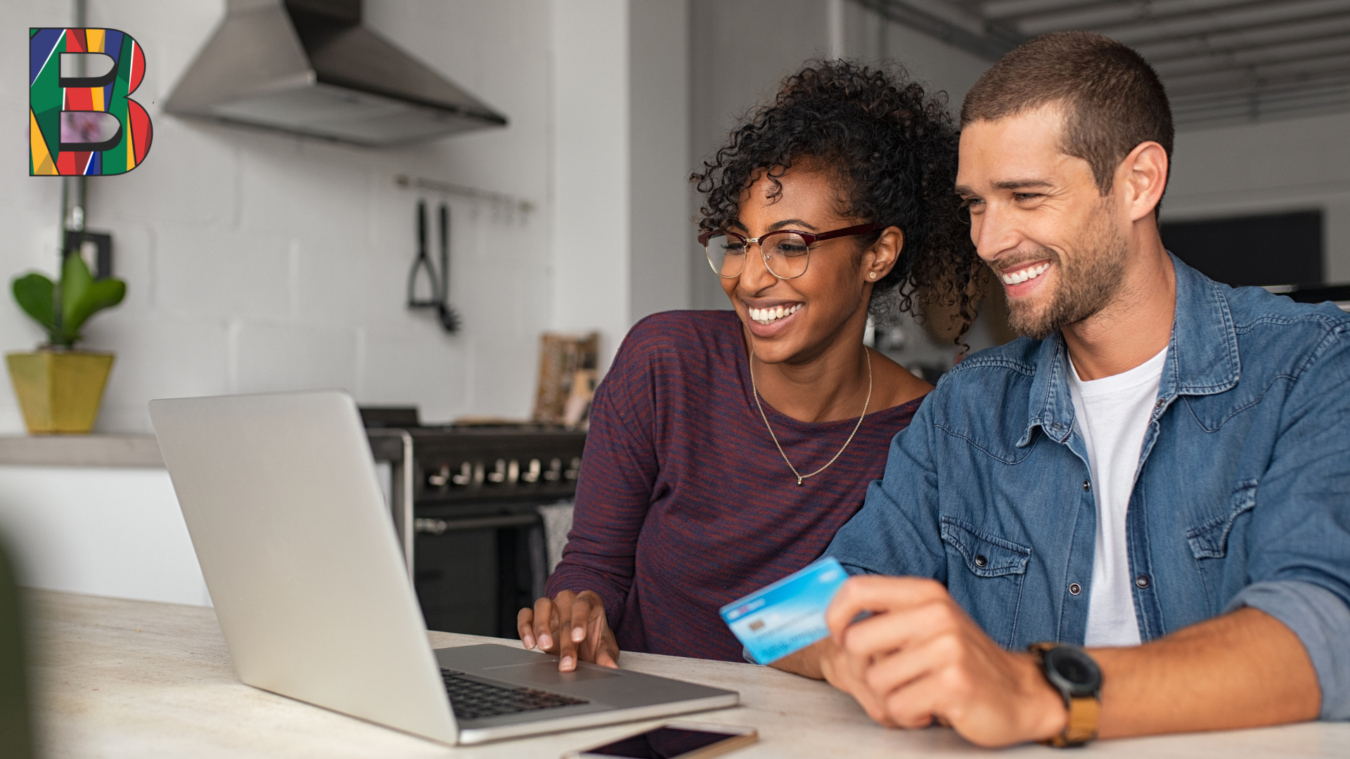 Smiling couple applying online for a Barko Financial Services loan using a laptop at home