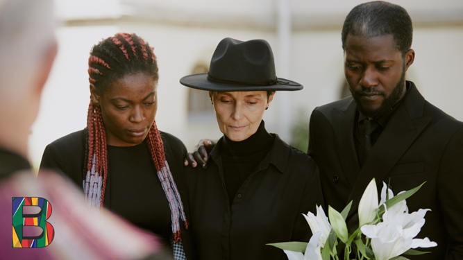 3 humans mourning at a funeral